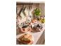 Ensemble de casseroles en cuivre avec casseroles et poêles sur un comptoir de cuisine avec des ingrédients frais.