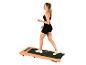 Femme sur un tapis de course Christopeit, portant une brassière de sport et un short noirs.