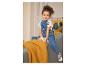 Fille en salopette en jean avec motif Minnie Mouse et t-shirt blanc, assise sur un canapé.