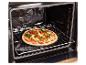Pizza aux légumes cuisant dans un four sur une pierre à pizza.