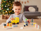 Een kind speelt met Duplo speelgoed, waaronder een gele bulldozer en een politiemotor.