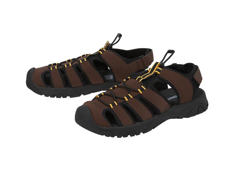 Een paar bruine en zwarte herensandalen met bandjes en gele details.