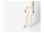 Femme portant un pull crème moelleux et un pantalon assorti avec des baskets blanches.