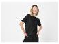 Vrouw in zwarte top met korte mouwen en witte details en zwarte broek.