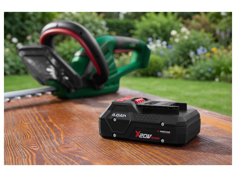 Batterie intelligente PARKSIDE PERFORMANCE 20 V / 4 Ah sur une table en bois avec un taille-haie.