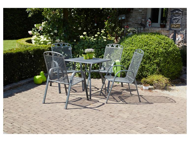 Ensemble de mobilier de jardin en métal gris avec table et quatre chaises sur une terrasse en briques.