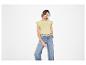 Vrouw in geel T-shirt met korte mouwen en wijde jeans.