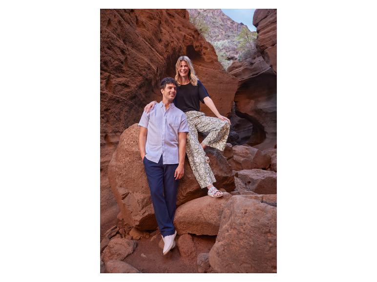 Homme en chemise à manches courtes et femme en pantalon large dans un canyon.
