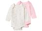 Deux bodys bébé à manches longues : un blanc à marguerites roses et un rose uni.