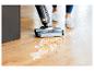 Bissell nat- en droogzuiger reinigt gemorste vloeistof op een houten vloer.