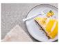 Stuk cheesecake met citroenglazuur, noten en kumquats op een bord