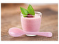Roze yoghurt met frambozen en een roze lepel.