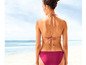 Een vrouw in een roze bikini op het strand.