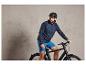 Man met helm op een zwarte fiets.