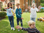 Kinderen spelen met zeepbellen en een speelgoedtruck in de tuin.
