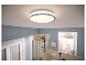 Plafonnier LED rond dans une salle de bain aux murs bleus et douche.