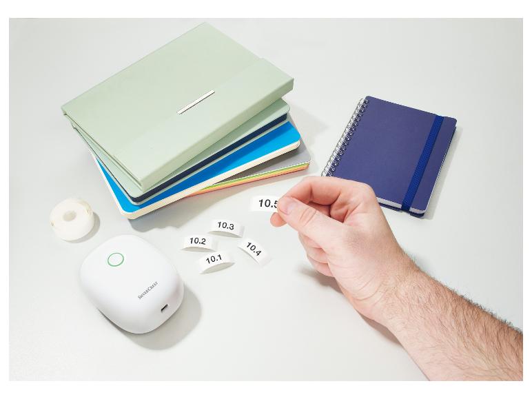 Een SilverCrest labelprinter met labels en notitieboekjes.