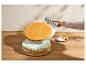 Main transférant une couche de gâteau ronde sur un gâteau à la menthe avec une spatule métallique.