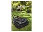 Tondeuse robot sur l'herbe avec une personne utilisant un smartphone en arrière-plan.
