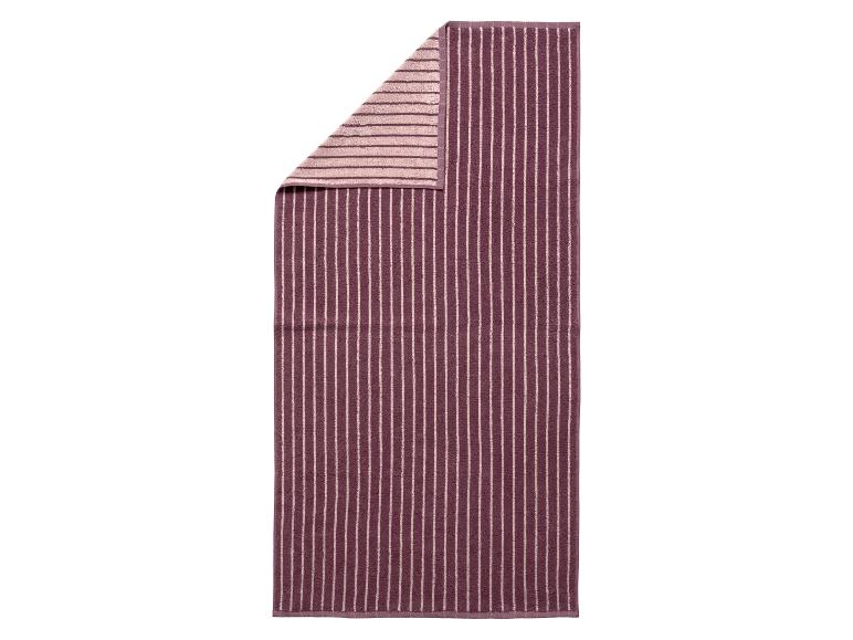 Verticaal gestreepte paarse en beige handdoek met een gevouwen hoek