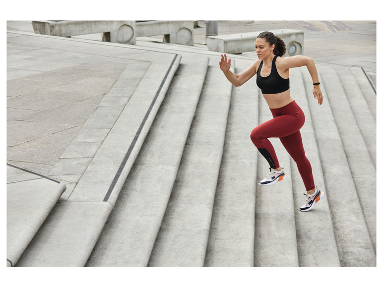 Femme en tenue de sport courant dans les escaliers.