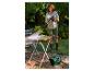 Femme nettoyant une table de jardin avec un nettoyeur haute pression.