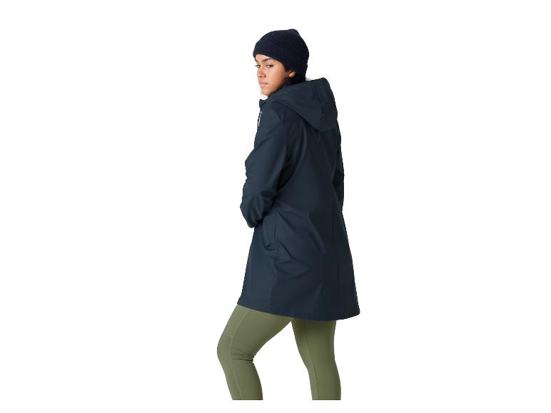 Vrouw met muts, donkerblauwe regenjas en olijfgroene legging.