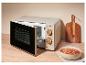 Micro-ondes beige avec porte ouverte, à droite un bol de soupe tomate avec croûtons.