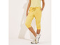 Pantalon de jogging capri jaune avec des baskets blanches.