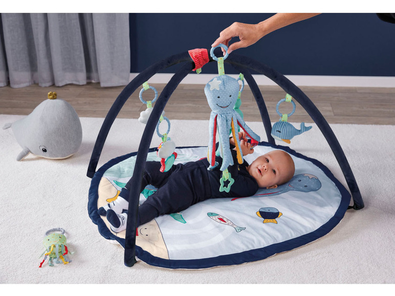 Baby op een speelmat met octopus en walvis-thema.