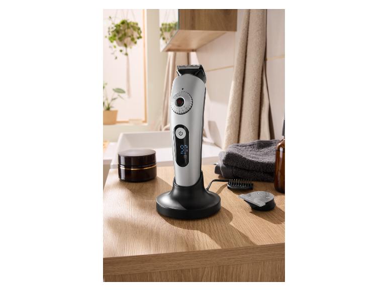 Haar- en baardtrimmer met digitaal display op laadstation in een moderne badkamer.