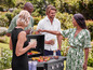 Een groep vrienden geniet van een barbecue met gegrilde groenten en vlees.