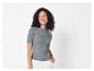Een vrouw draagt een grijs gebreid shirt met korte mouwen.