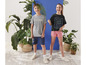 Deux enfants portant des t-shirts et des shorts avec des imprimés 'Champ' et 'Travel the World'.