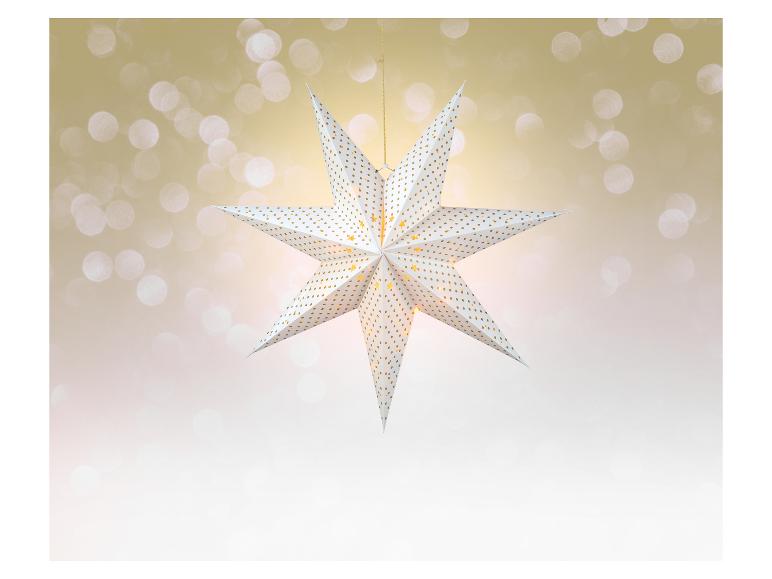 Lichtgevende kerstster met gouden patroon op een bokeh-achtergrond.