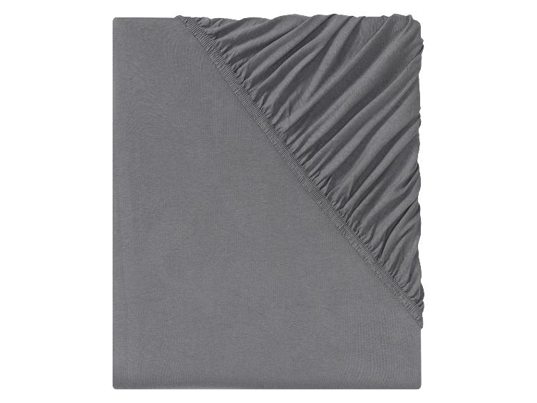 Un drap housse en coton gris avec élastique.