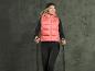 Femme portant un gilet rose Explorer avec des bâtons de randonnée.