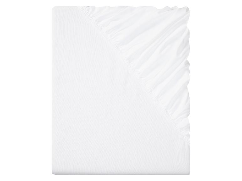 Drap-housse blanc plié en rectangle.