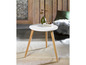 Table basse blanche avec pieds en bois dans un intérieur moderne.