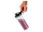 Hand houdt transparante fles met paarse smoothie vast