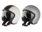 Deux casques de moto rétro, un blanc à rayures rouges et un gris.