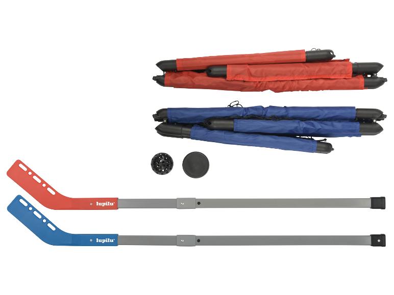 Deux crosses de hockey, un palet, une balle et deux ensembles de buts de hockey pliés en rouge et bleu.
