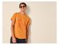 Homme en t-shirt orange avec imprimé surf et lunettes de soleil, souriant.