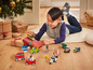 Een jongen speelt met LEGO DUPLO voertuigen en verkeersborden.