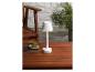 Une lampe blanche avec un abat-jour sur une table en bois.