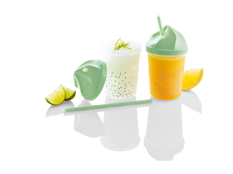 Deux verres avec des pailles, l'un avec du jus d'orange et l'autre avec une boisson blanche, décorés de confettis.