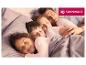 Famille dormant au lit sous des couettes SANNWALD.