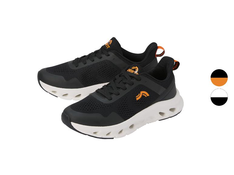 Une paire de chaussures de sport noires avec des détails orange et une semelle blanche.