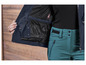 Een blauwe jas met een RECCO-reflektor en een groene broek.