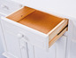 Een witte dressoir met een open lade.